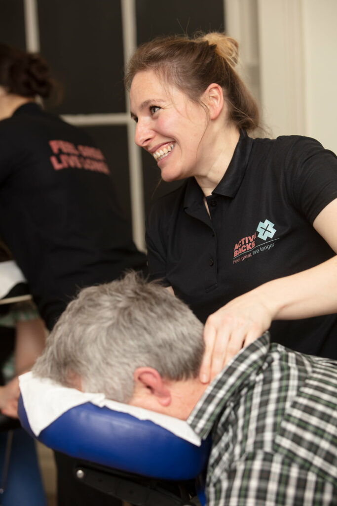 AXB seated massage smiling https://active-x.co.uk/treatments/office-massage-edinburgh/